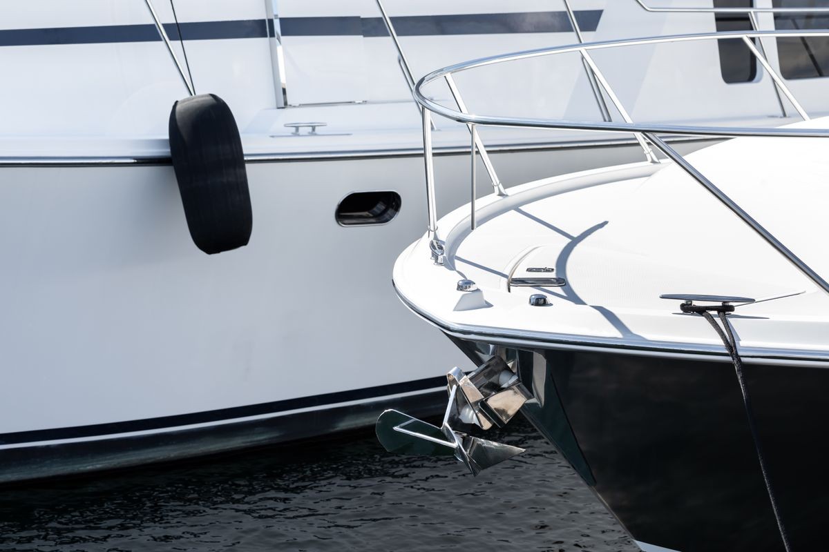 Close up on the bow deck of a luxury yacht and front anchor, with boat hull in the blurry background and space for text on left